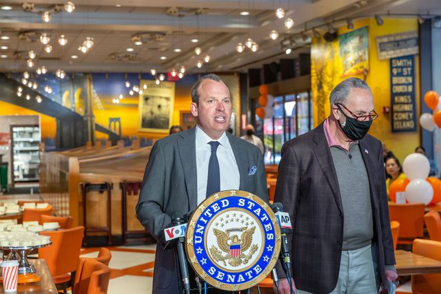 A photo of Alan Rosen and US Senator Charles Schumer at the reopening of Junior's in Times Square in May 2021